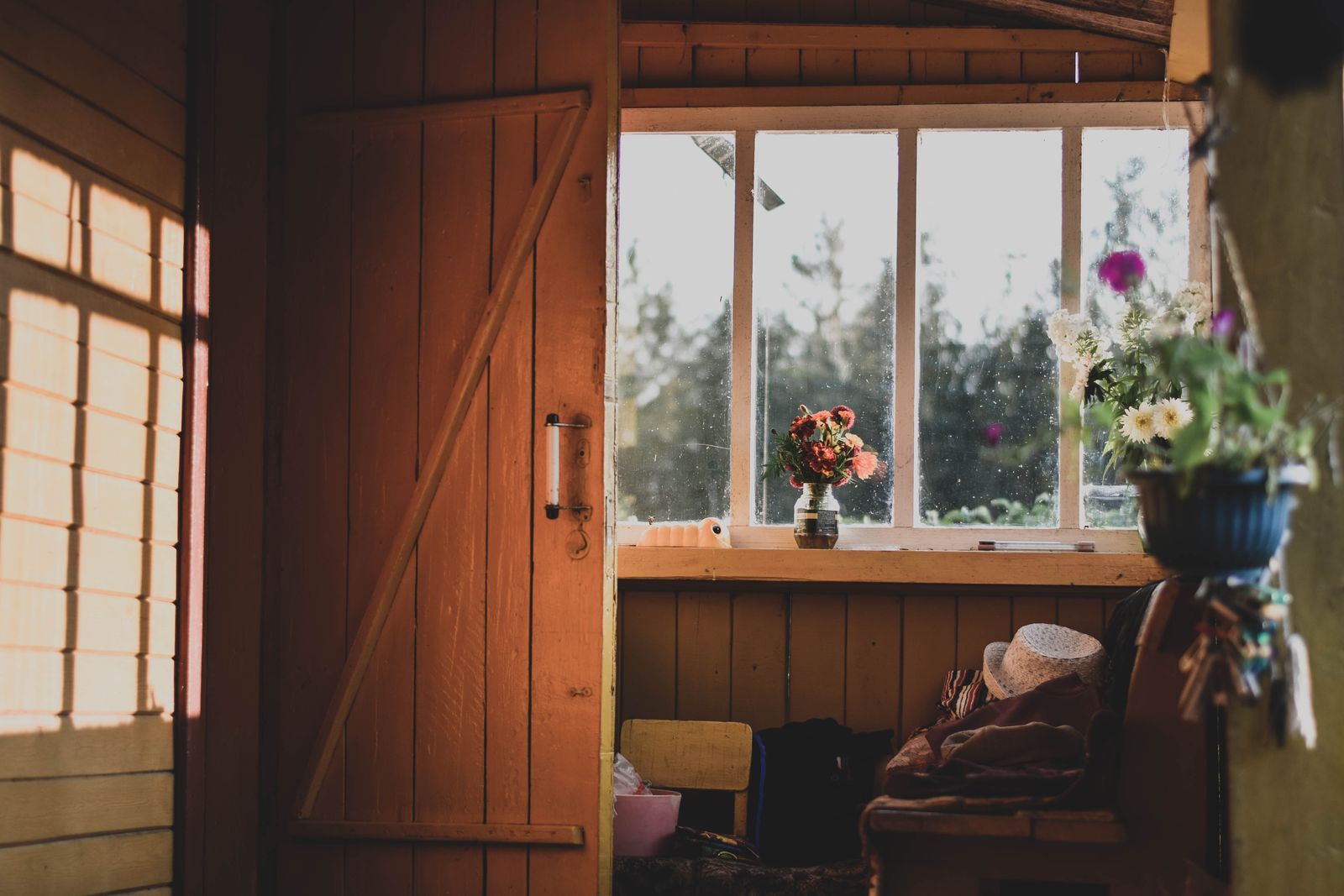 A warm cottage doorway with flowers on the windowsill, the kind of welcome guests remember