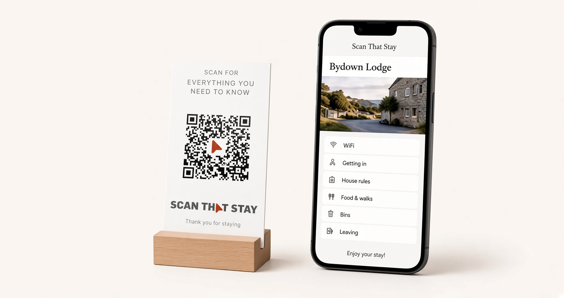 A printed Scan That Stay QR plaque in a wooden stand, next to a phone showing the guest page it opens
