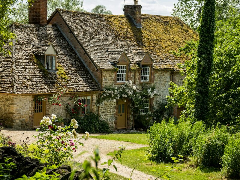 Honey stone Cotswold cottage with roses and a lawn in Bourton-on-the-Water